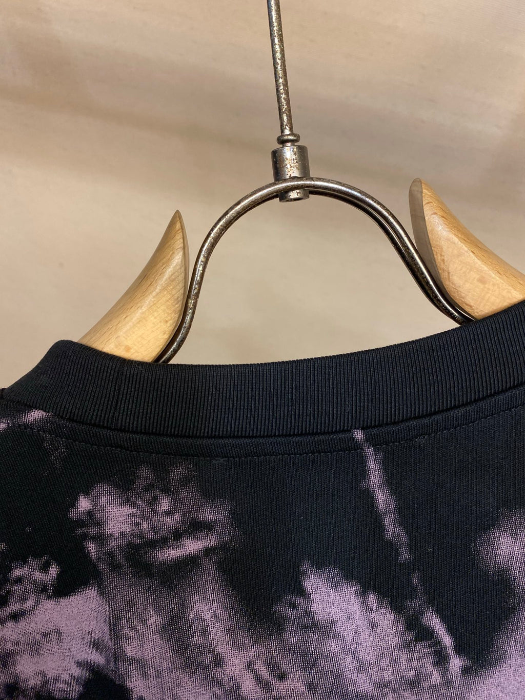 T-shirt neckline and collar seam on dark fabric with purple splatter pattern