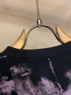 T-shirt neckline and collar seam on dark fabric with purple splatter pattern