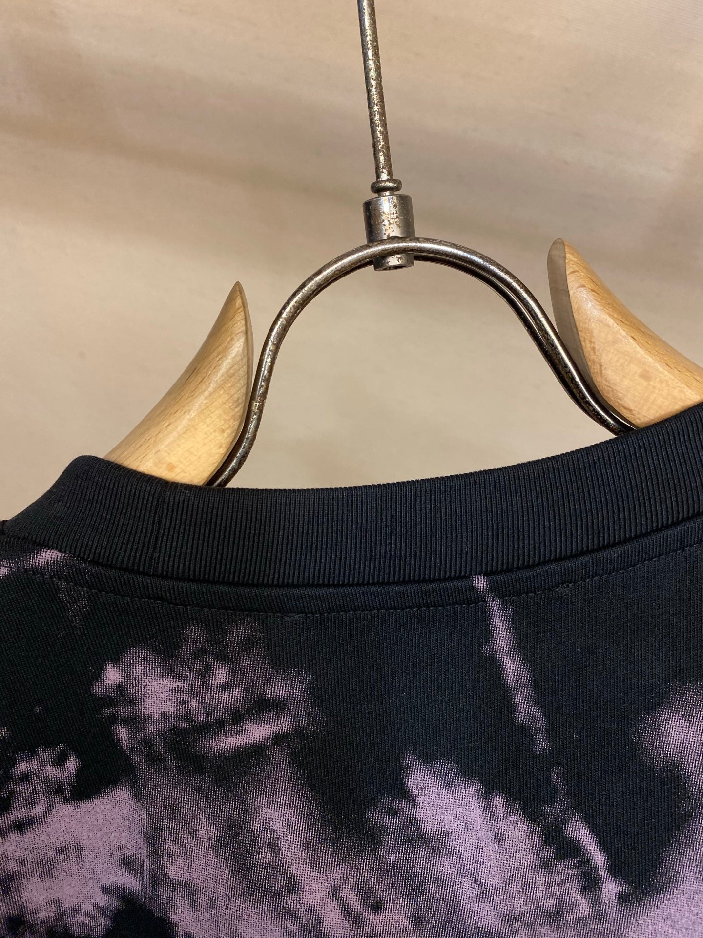 T-shirt neckline and collar seam on dark fabric with purple splatter pattern