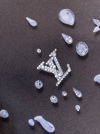 Louis Vuitton dark fabric with silver-like icon pattern, detail close-up