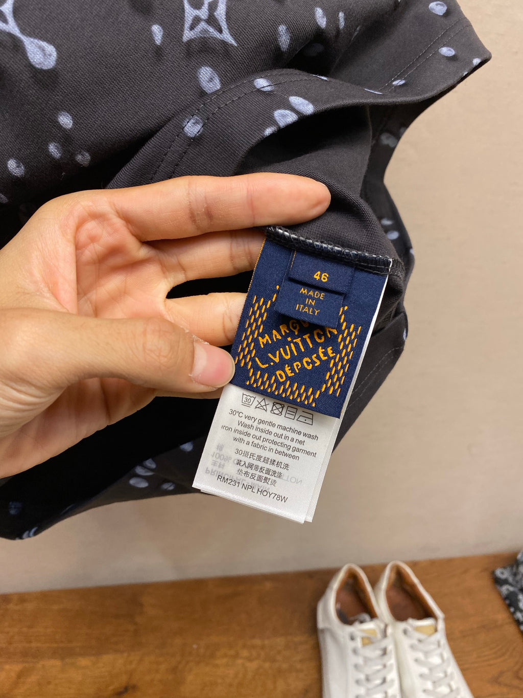 Louis Vuitton inner care label on dark T-shirt, size and text tag visible