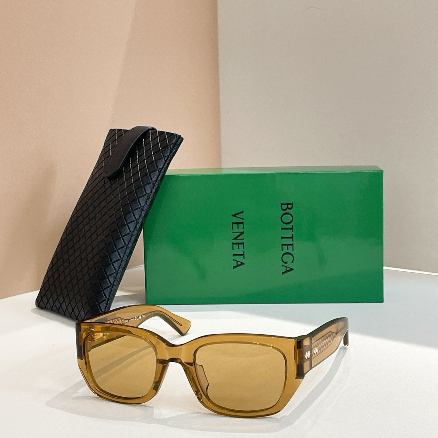 Gold-tone sunglasses with square lenses and gold-tone logo detail on frame