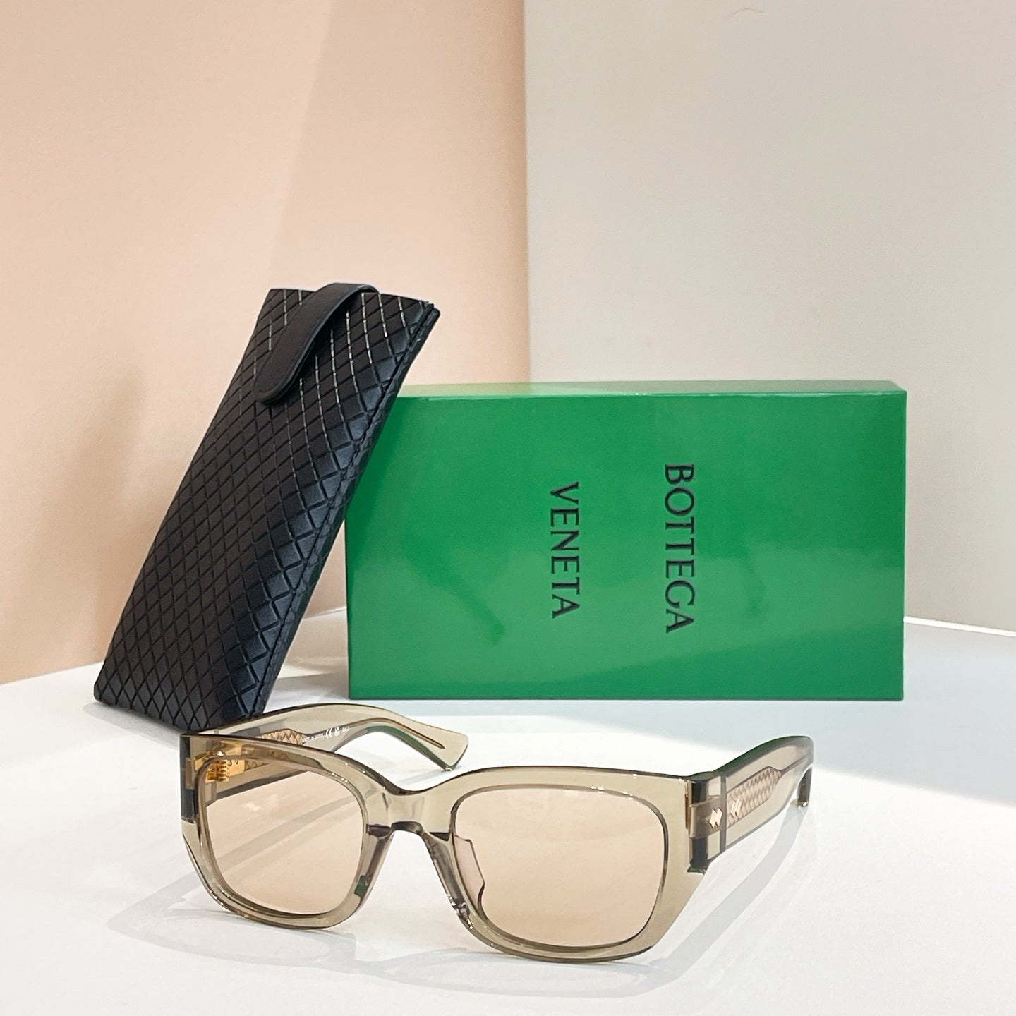Light beige sunglasses with square lenses and gold-tone logo detail on frame