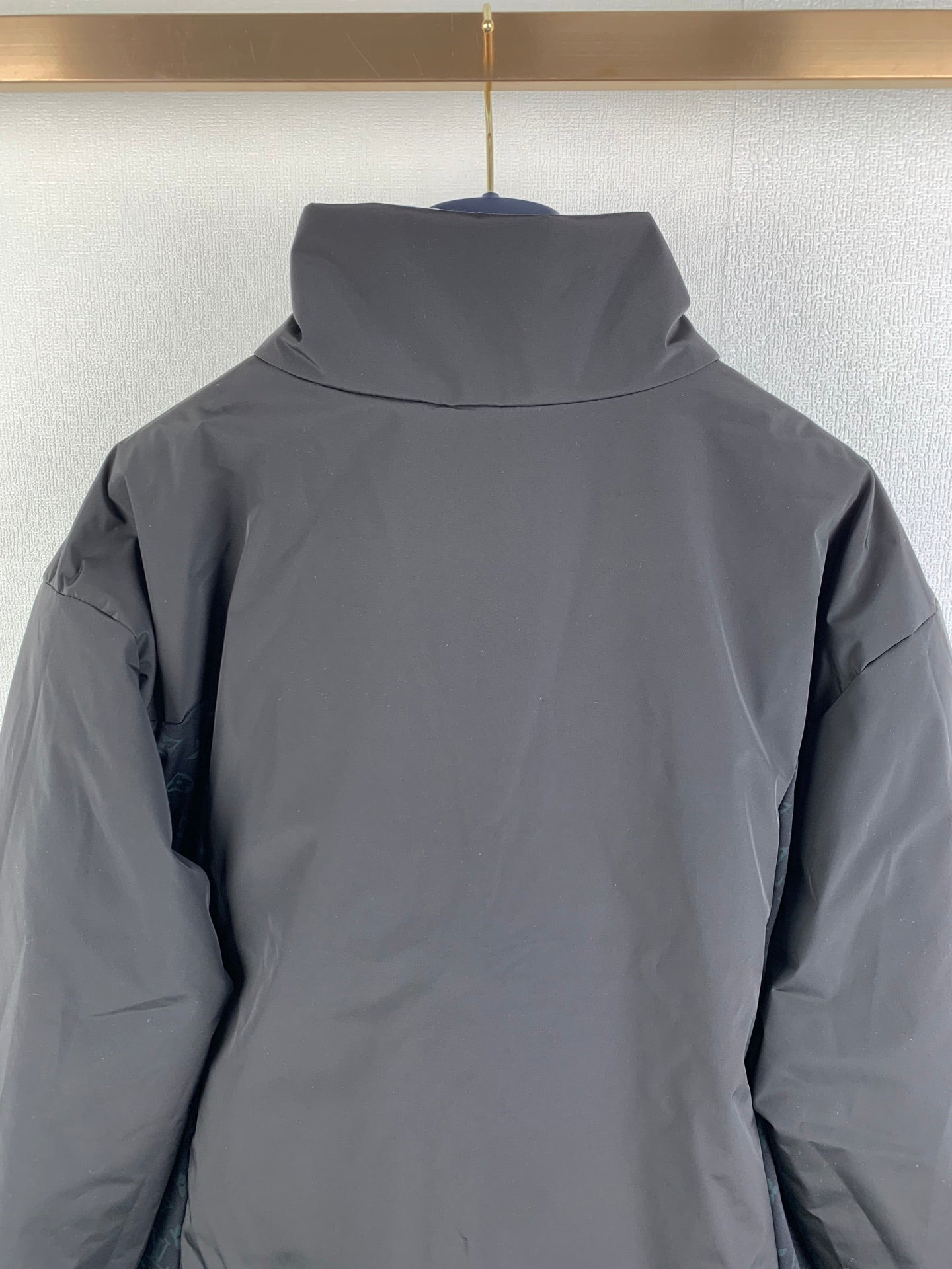 Dark gray hooded jacket back with high collar.