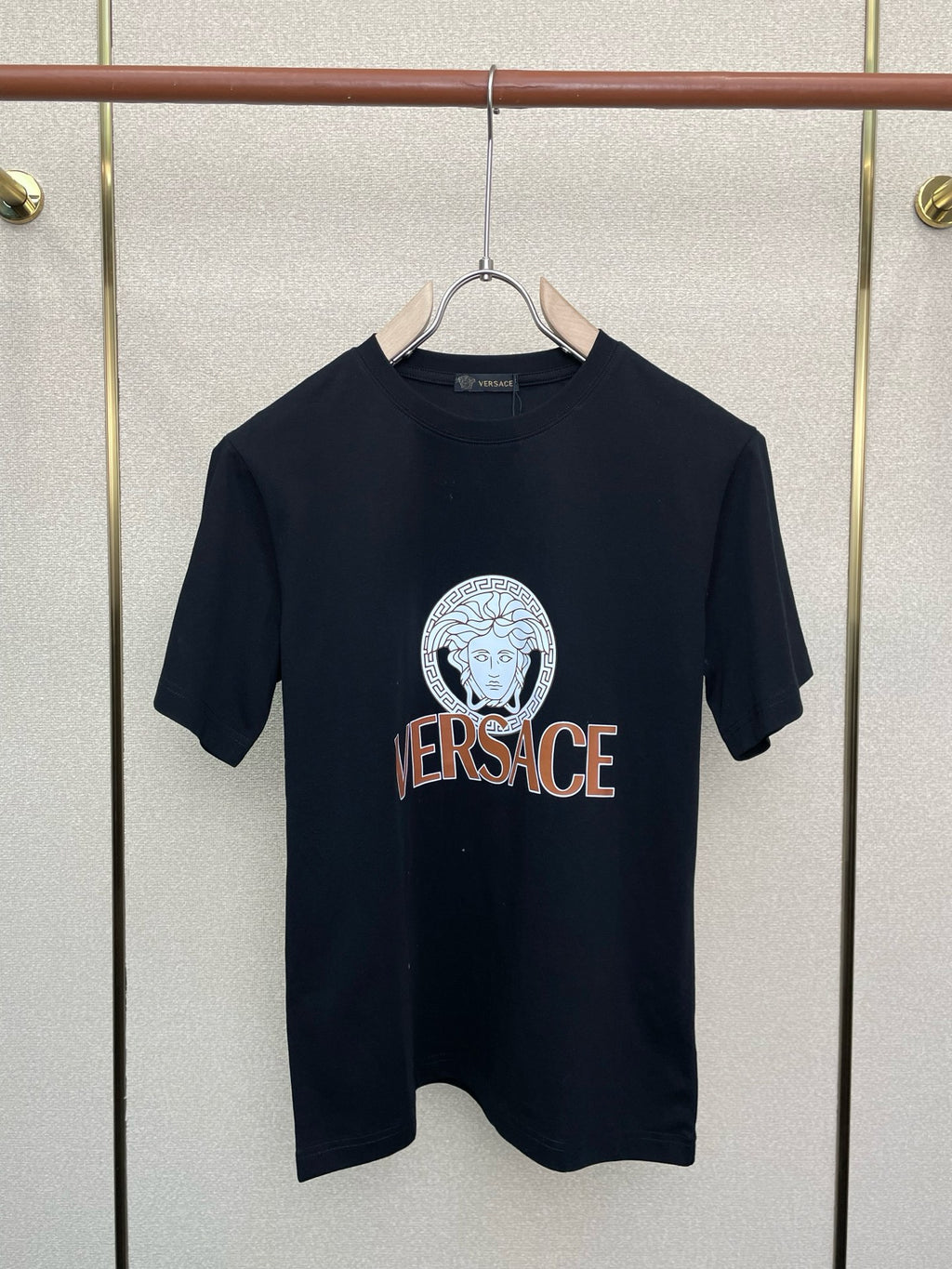 Black crewneck T-shirt with circular Medusa-style emblem and VERSACE text