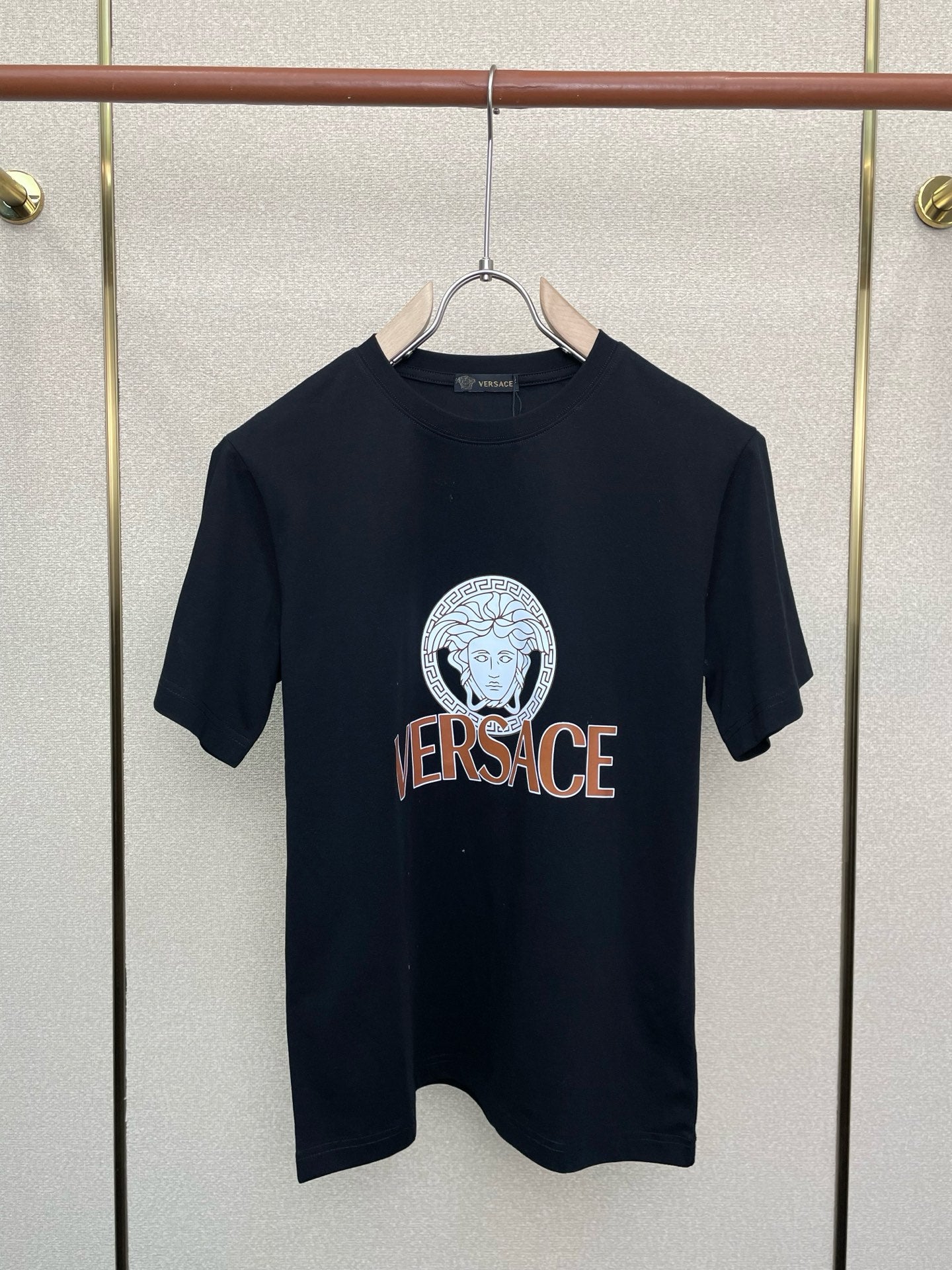 Black crewneck T-shirt with circular Medusa-style emblem and VERSACE text