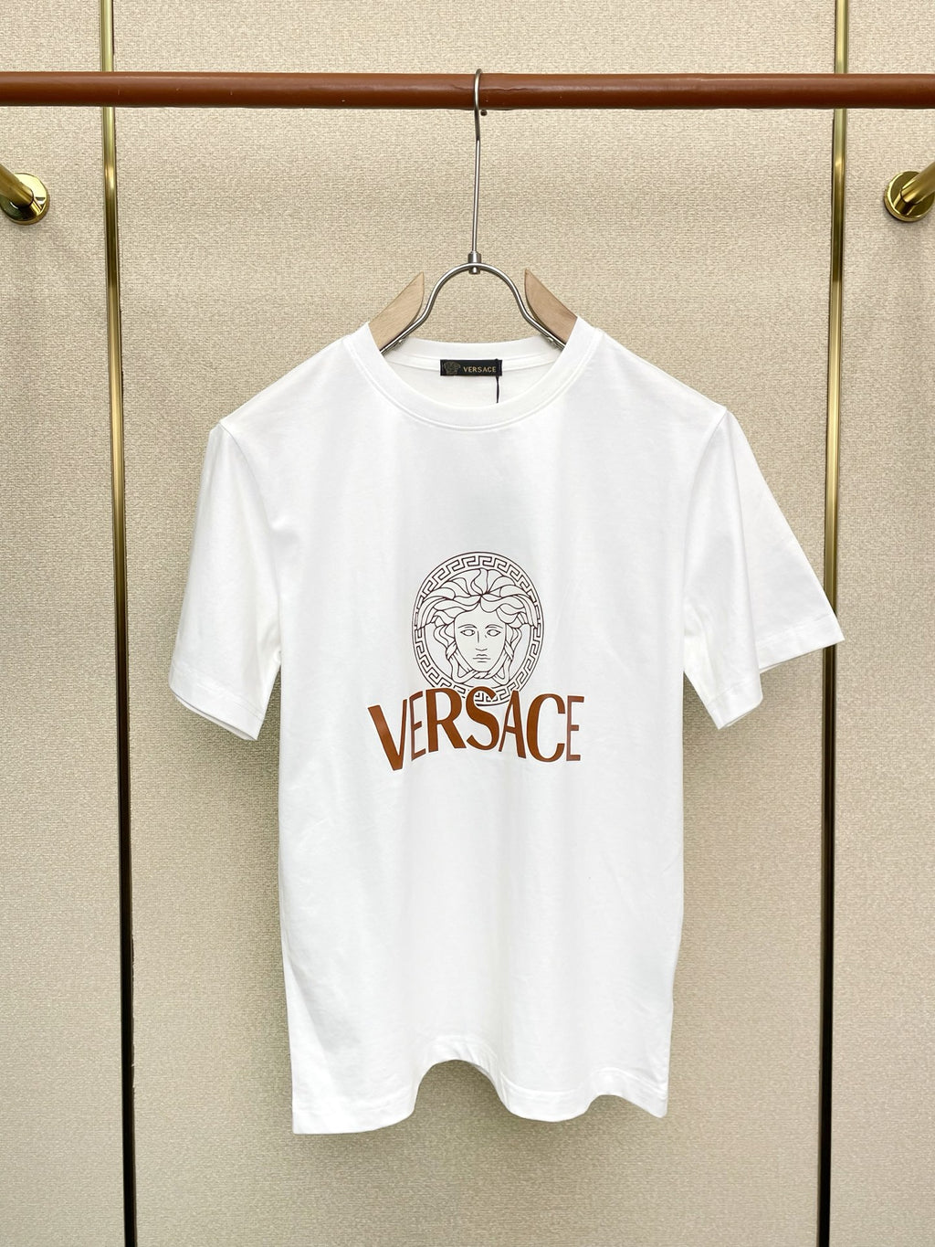 White Versace graphic T-shirt hanging on a hanger