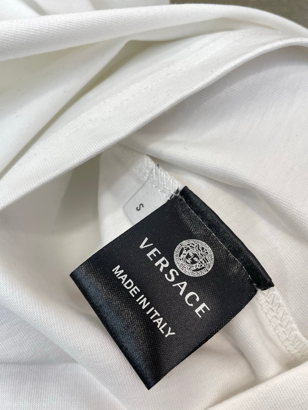 White T-shirt fabric with Versace label reading MADE IN ITALY