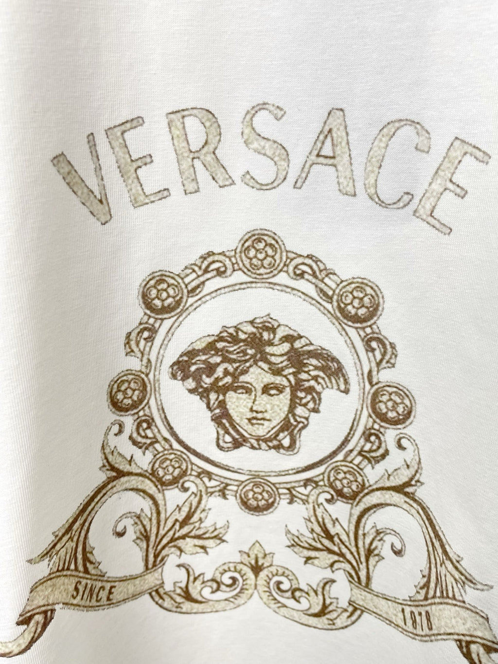 White Versace crewneck T-shirt close-up of ornate gold head medallion