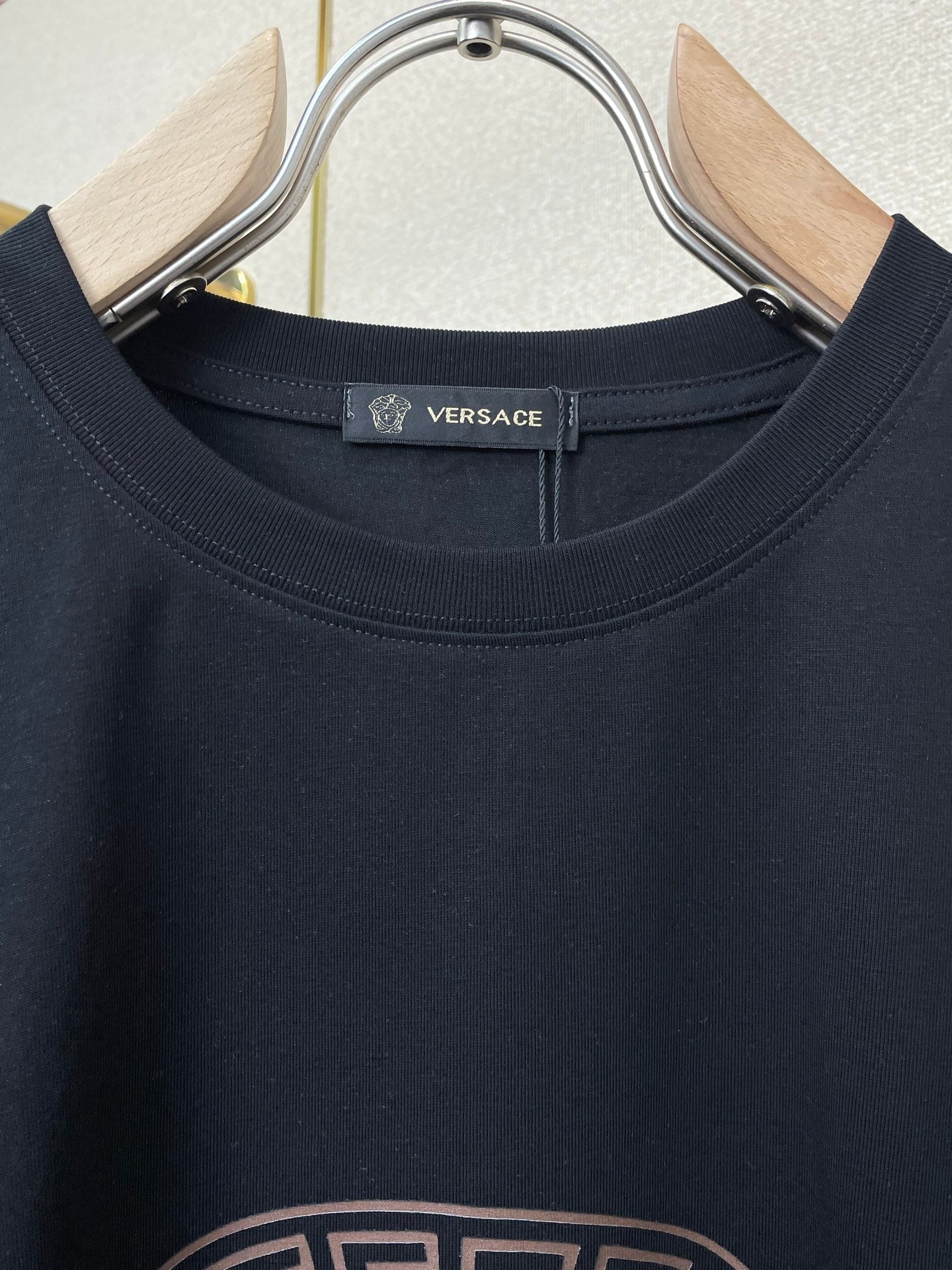 Versace crew-neck T-shirt neckline and upper chest on dark fabric