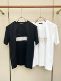 Black and white Versace graphic T-shirts on hangers, crew neck, short sleeves.