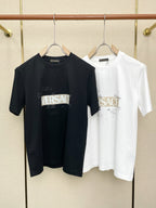 Black and white Versace graphic T-shirts on hangers, crew neck, short sleeves.