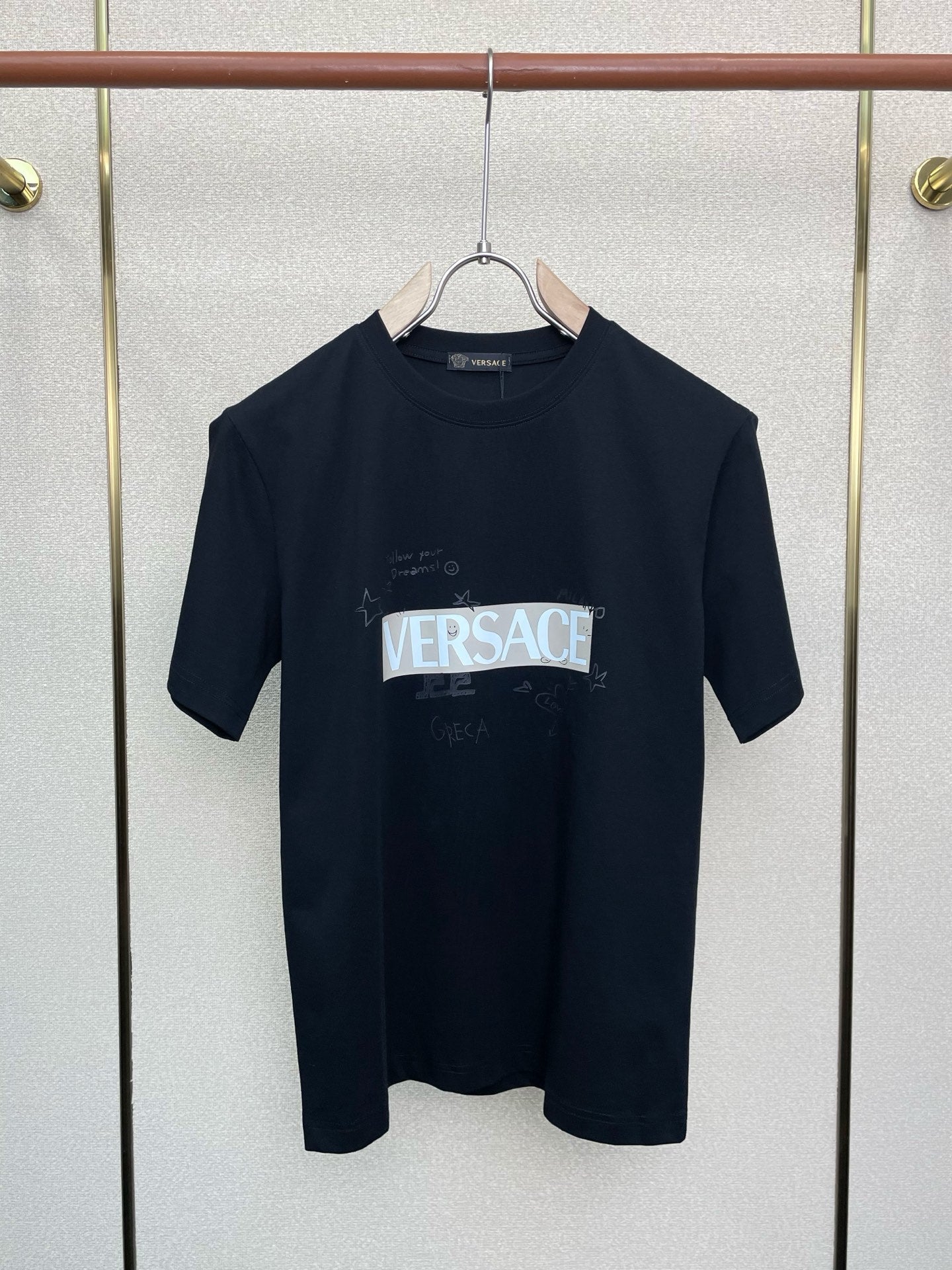 Navy Versace logo graphic T-shirt on hanger, crew neck, short sleeves.