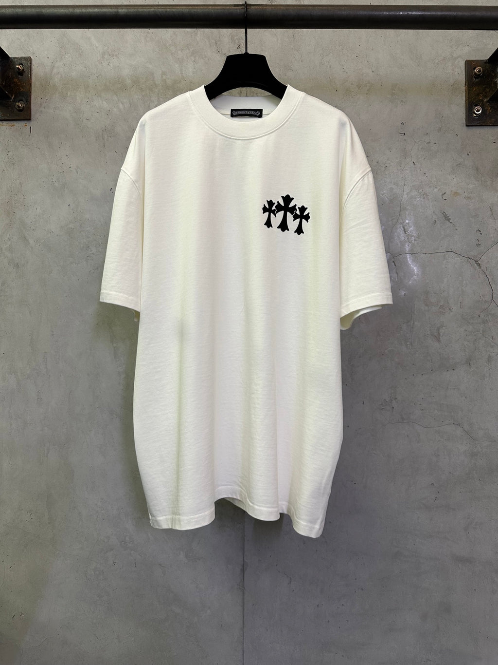 White crew-neck T-shirt with black cross-like logo graphic on chest