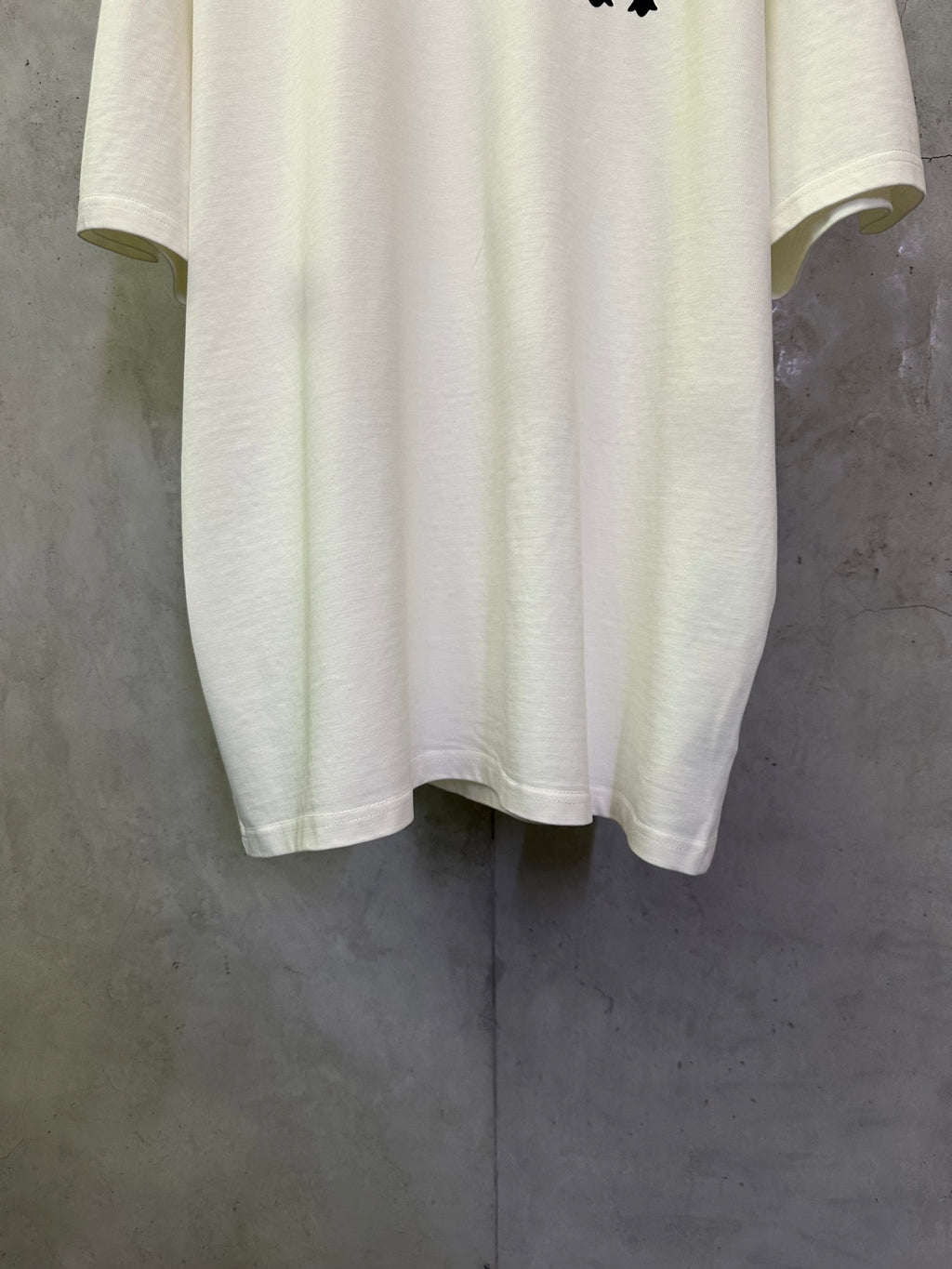 White short-sleeve T-shirt hem with curved bottom and visible stitching