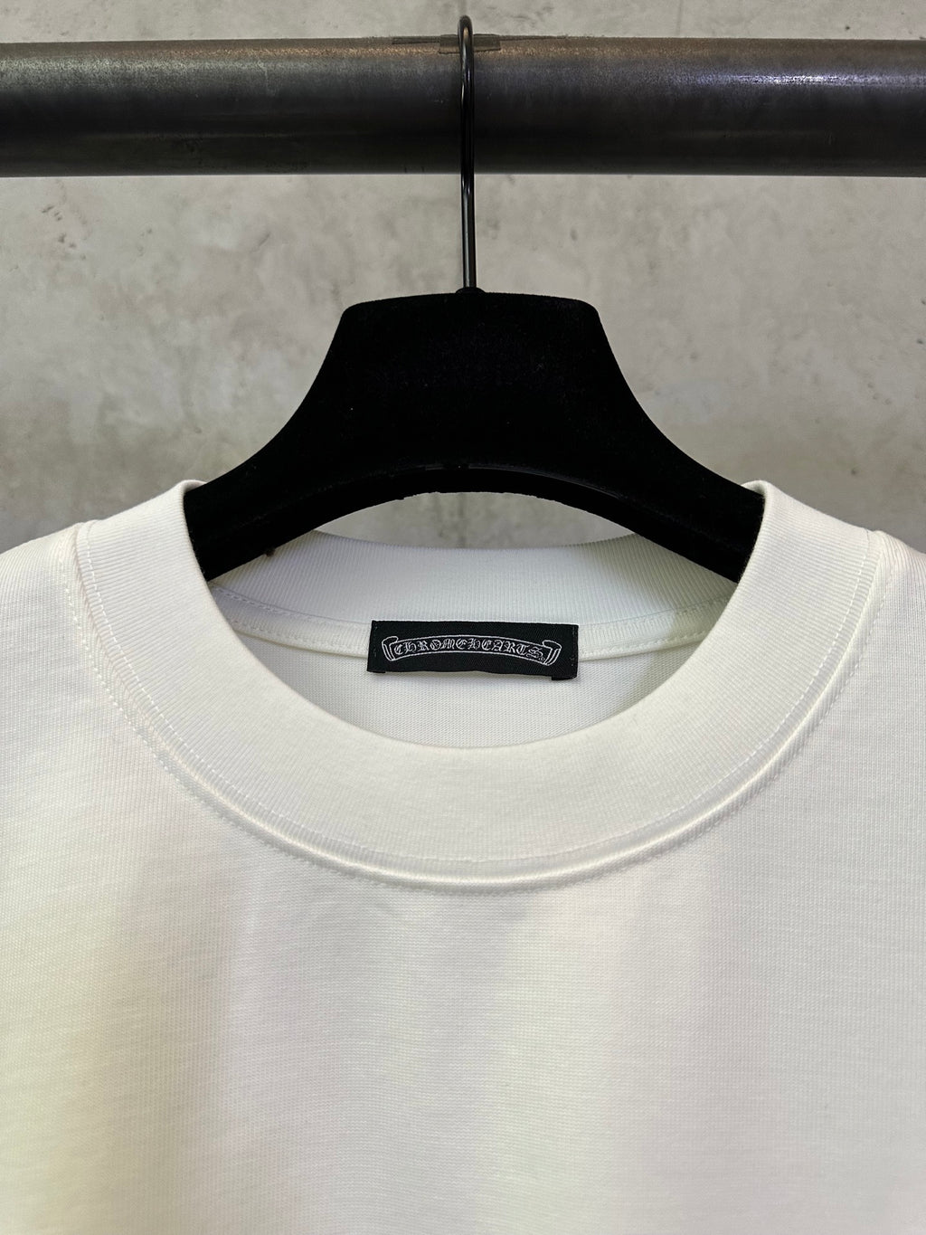 White crew-neck T-shirt with black brand label at collar