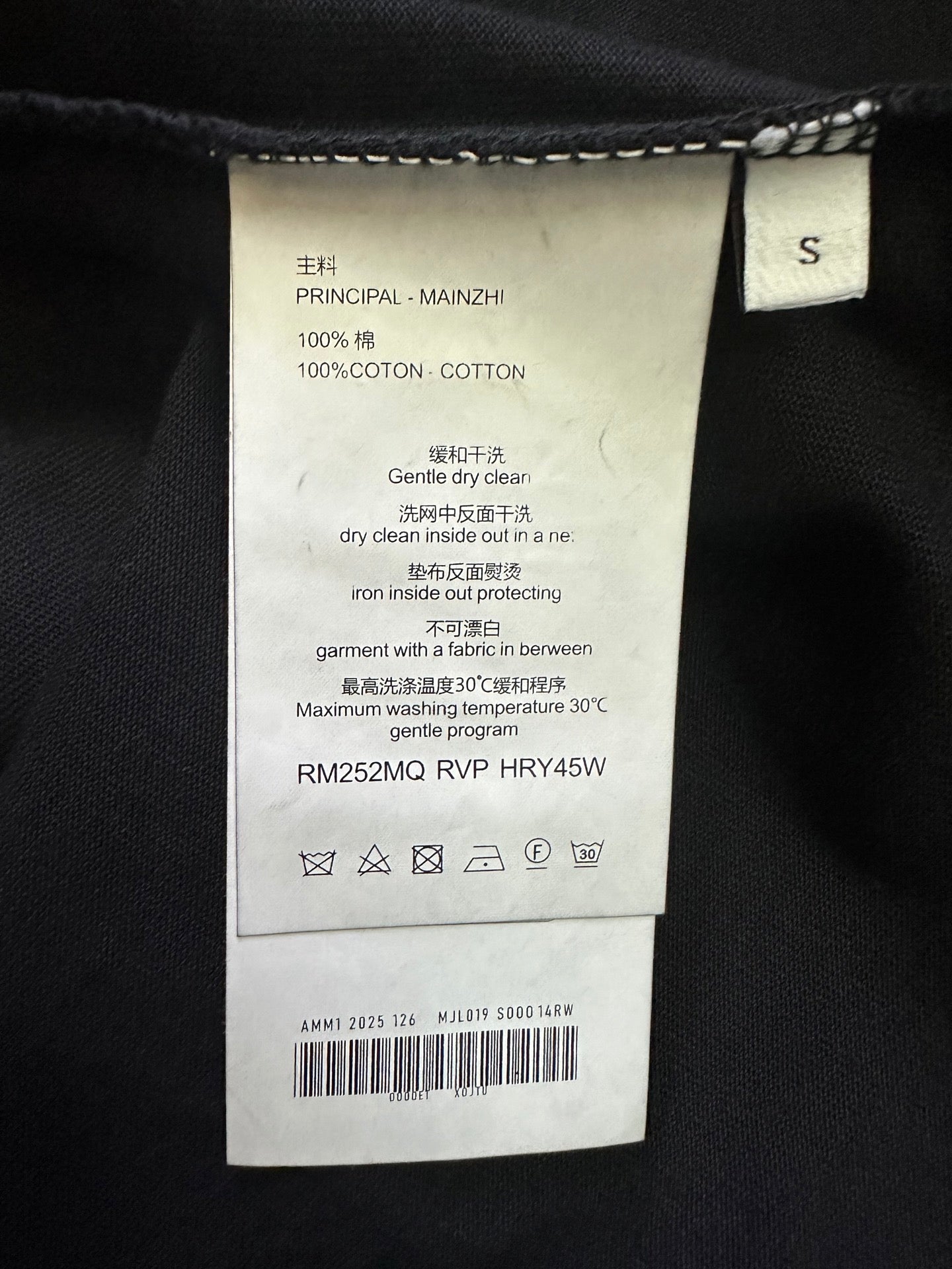 Black T-shirt size S care label with cotton content and washing instructions