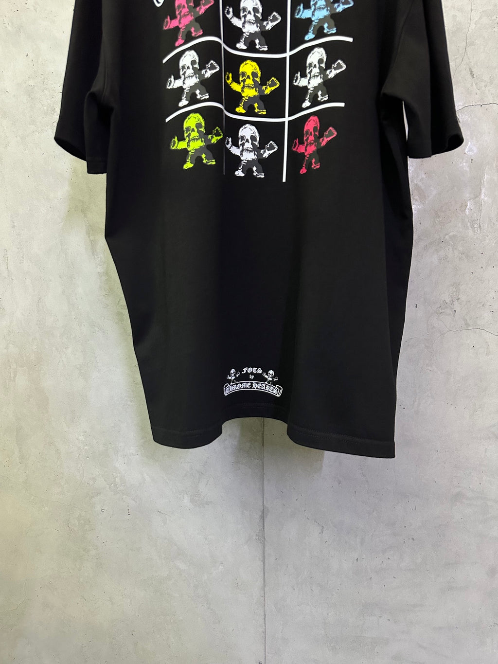 Black crewneck T-shirt with colorful skeleton grid graphic and small hem text