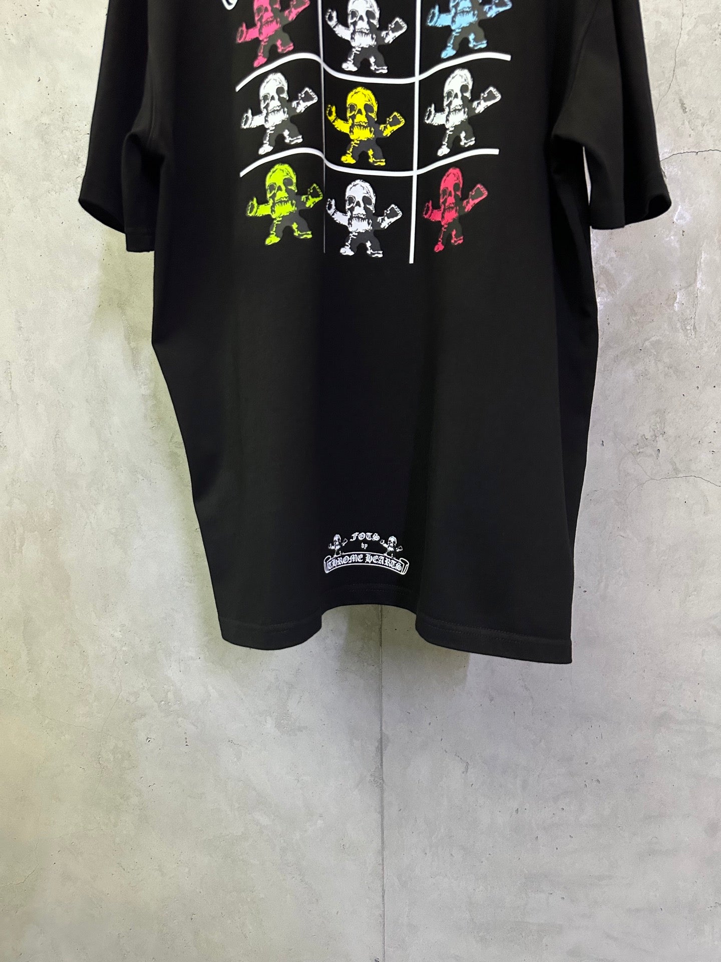 Black crewneck T-shirt with colorful skeleton grid graphic and small hem text