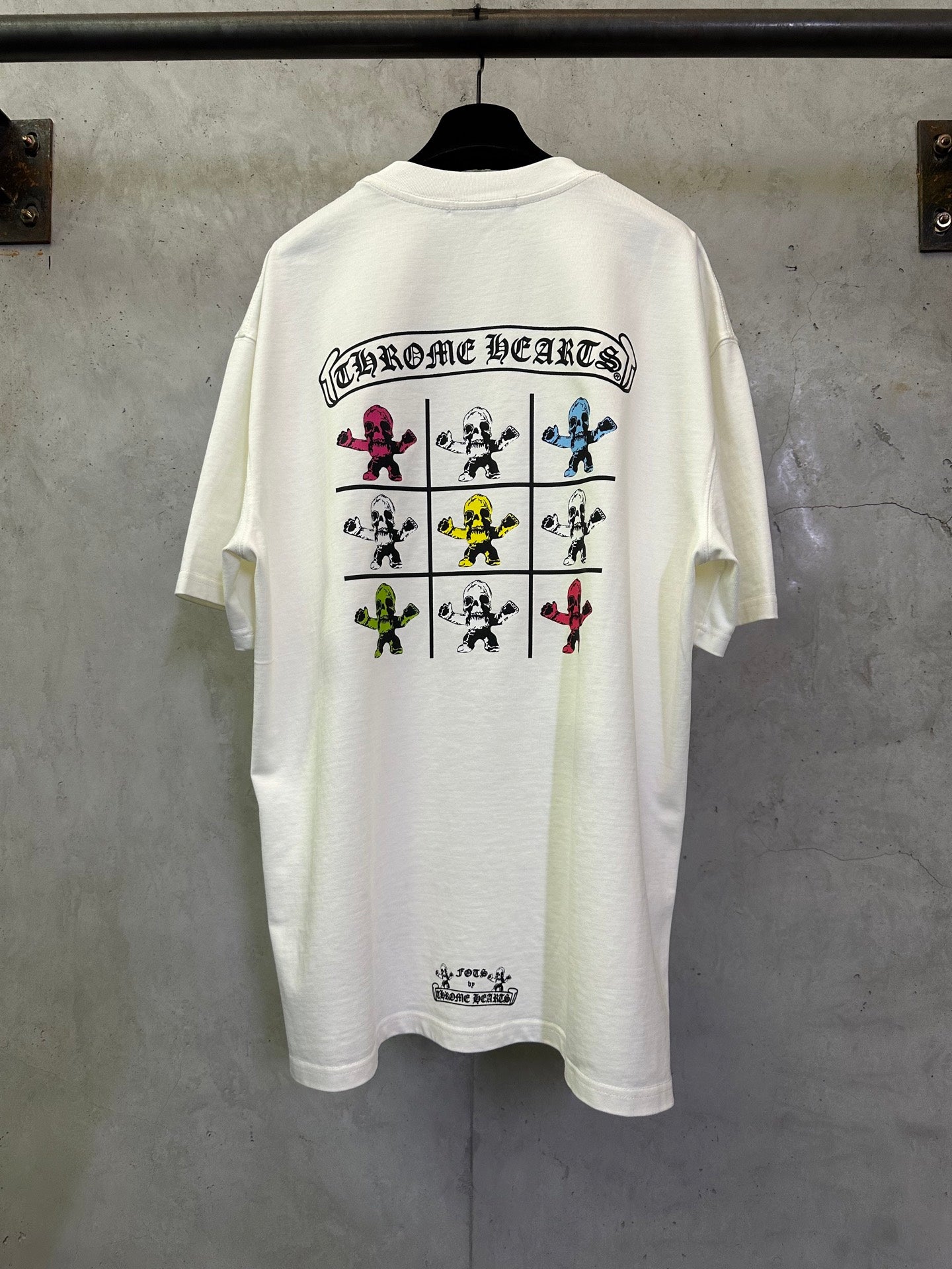 White graphic T-shirt back with character grid illustration and arched text, crew neck.