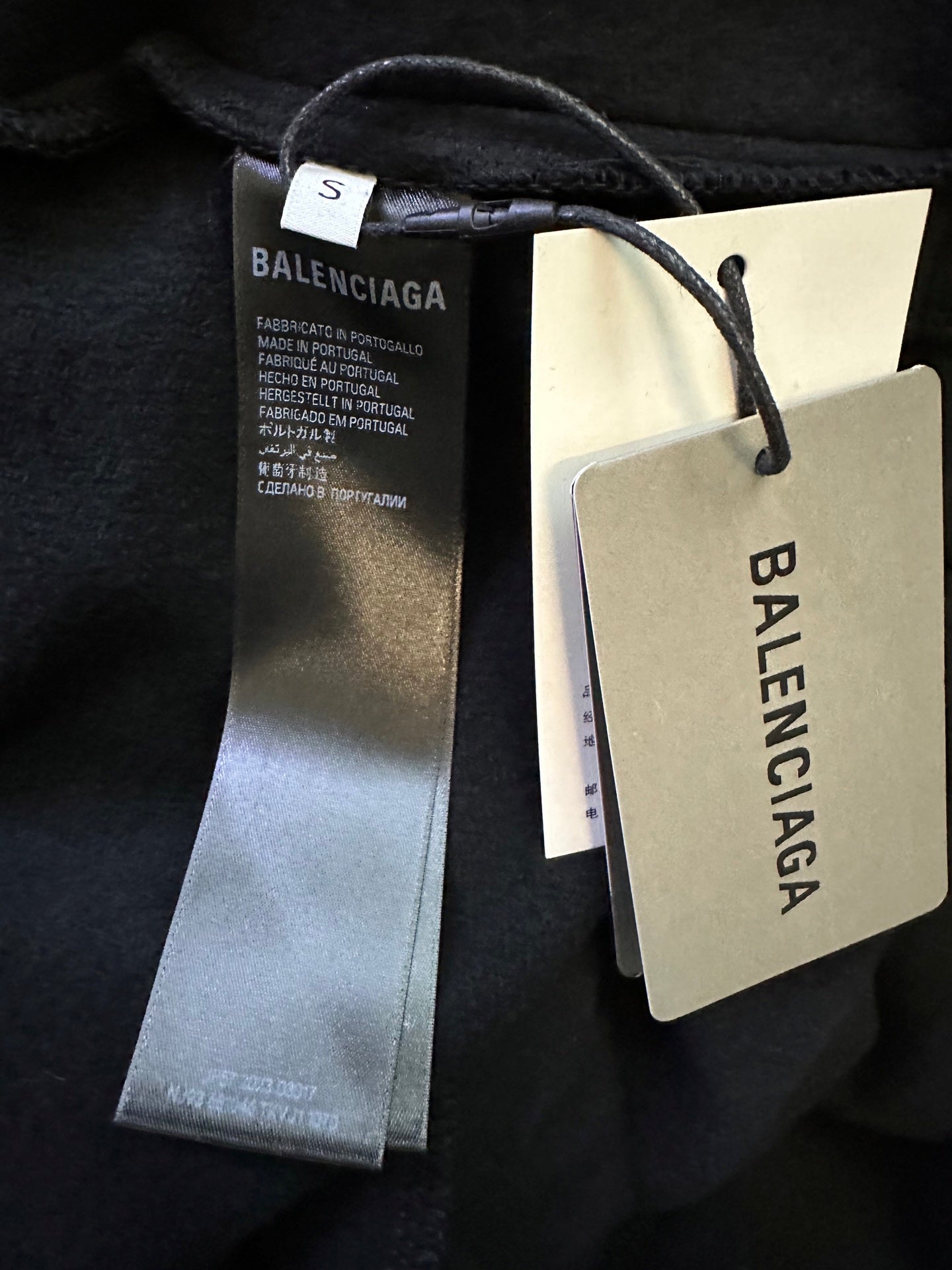 Black track pants with attached Balenciaga fabric tag and size tag
