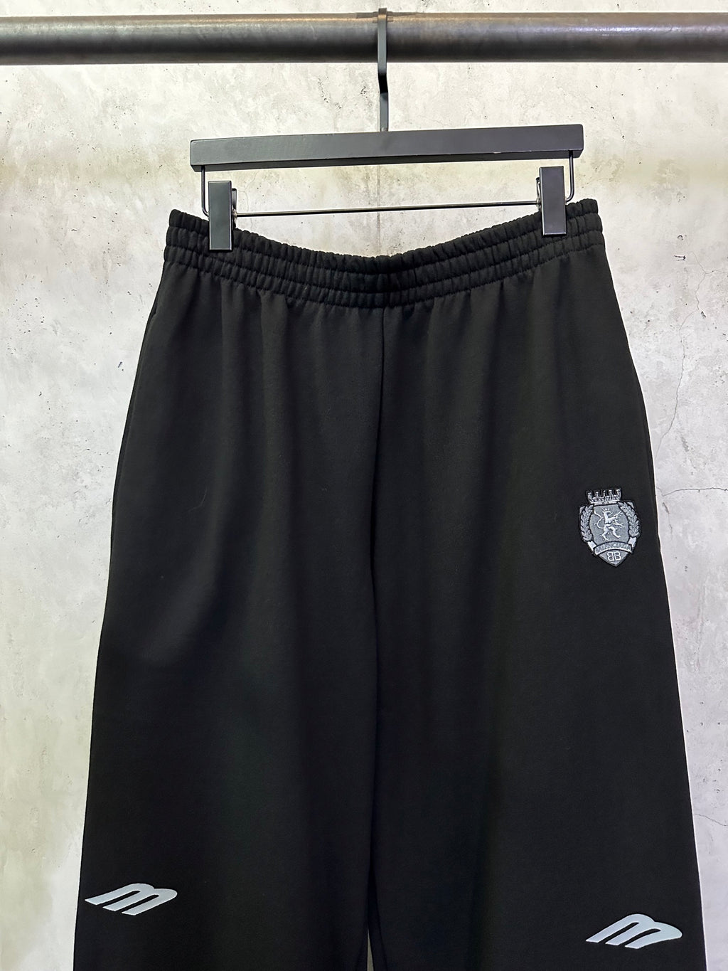 Black Balenciaga track pants with elastic waistband and side crest patch