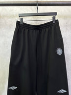Black Balenciaga track pants with elastic waistband and side crest patch