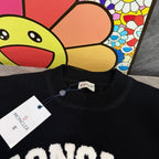 Black crewneck sweater neckline with Moncler tag and ribbed knit collar