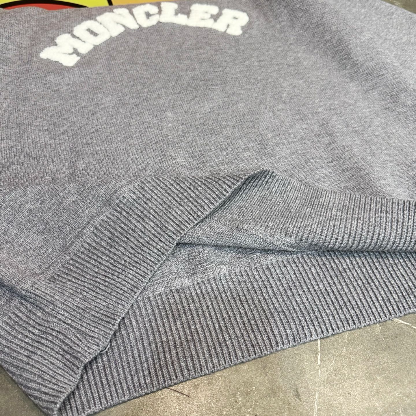 Light gray sweater ribbed cuffs and knit hem detail