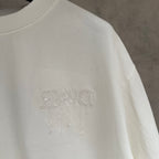 White Dior short-sleeve T-shirt side close-up with embossed logo