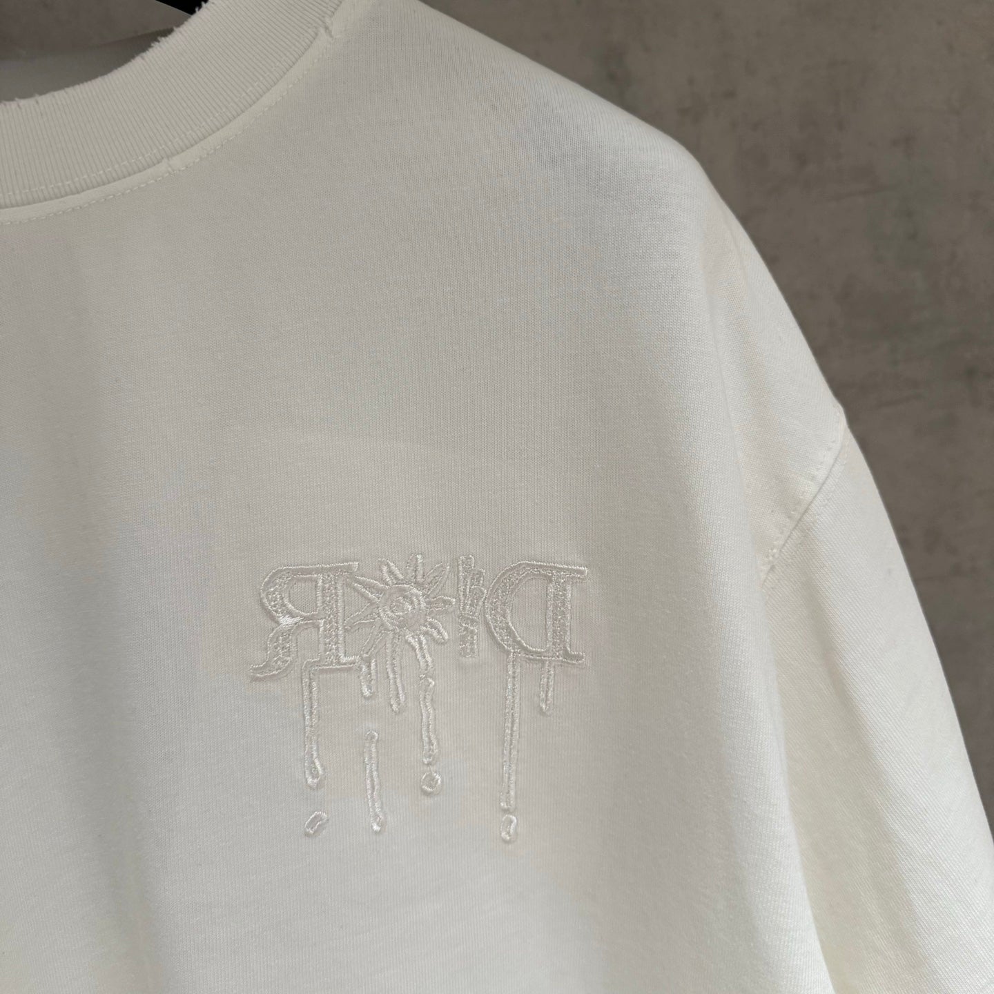 White Dior short-sleeve T-shirt side close-up with embossed logo