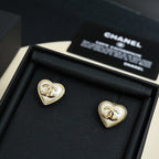 Heart-shaped Chanel stud earrings with white enamel and gold trim in display box