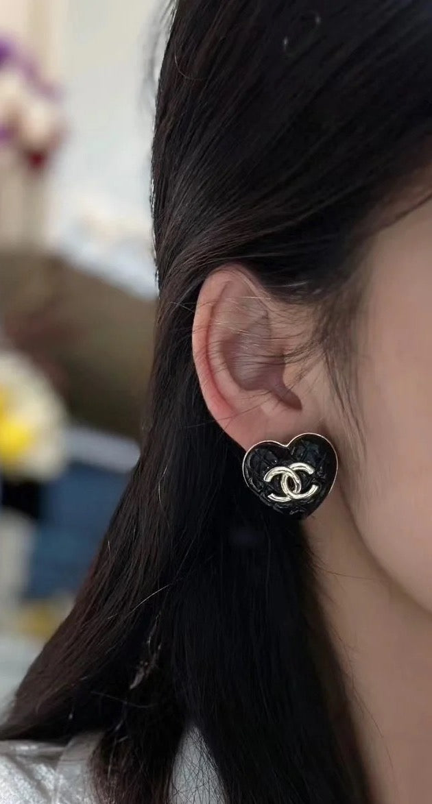 Chanel heart stud earrings on ear: black heart with gold CC logo
