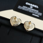 Chanel heart stud earrings close-up: gold-toned heart with CC logo studs