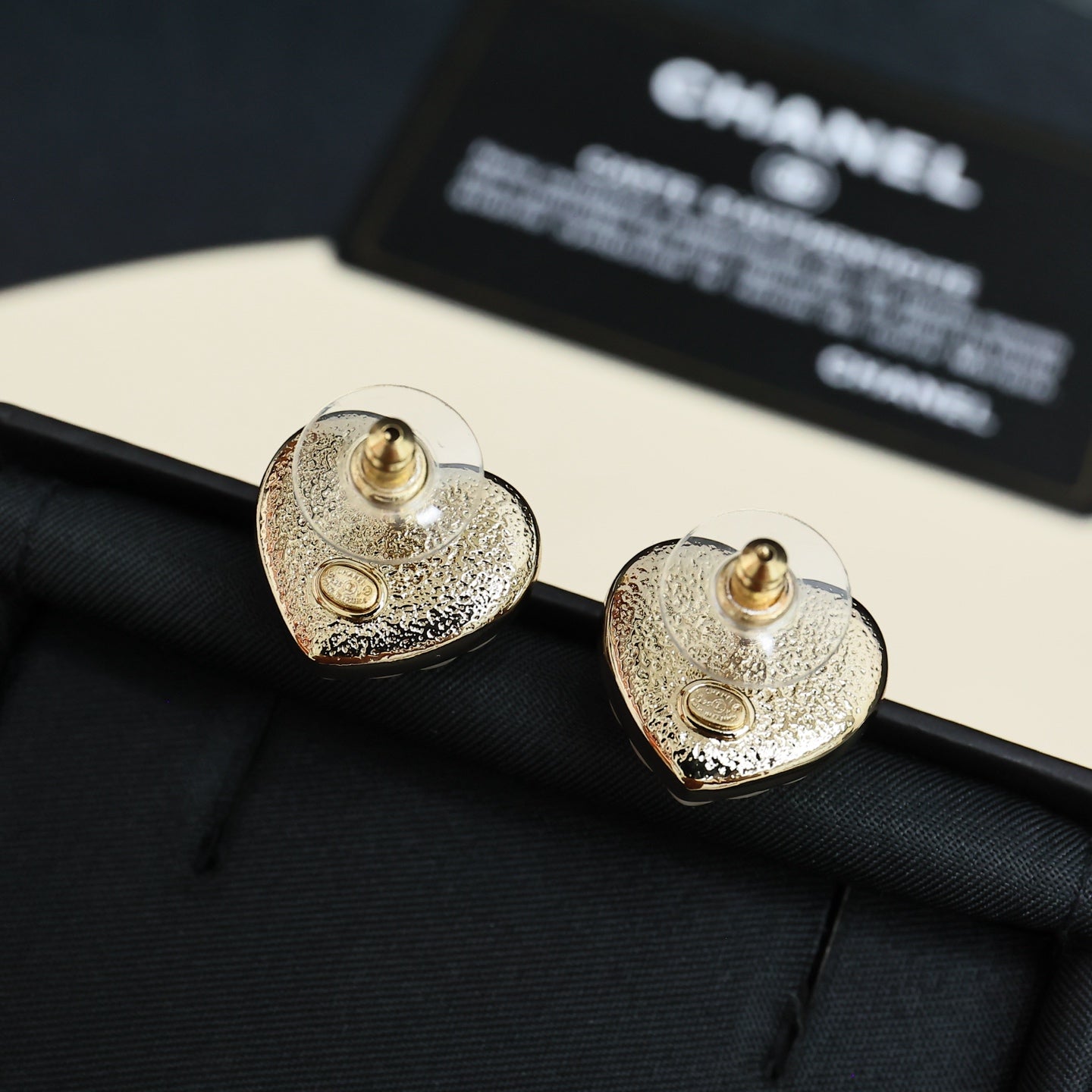 Chanel heart stud earrings close-up: gold-toned heart with CC logo studs