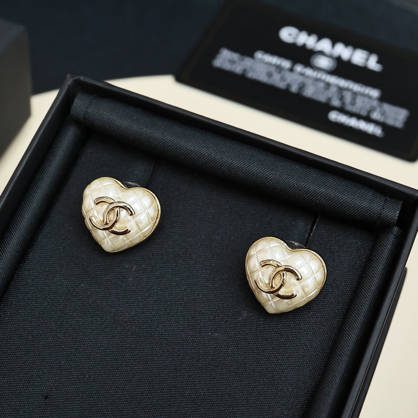 Chanel heart stud earrings: white heart with gold CC logo, in black box