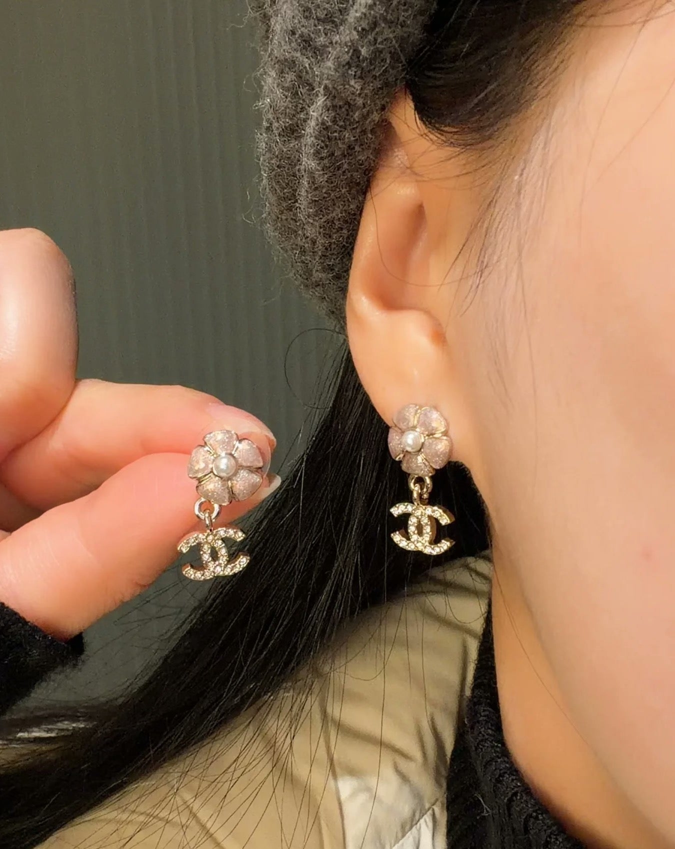 Chanel earrings worn: pearl flower studs with dangling CC logo charms