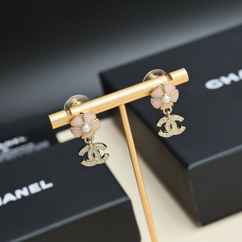 Chanel earrings with gold-tone bar display, pink flower studs, pearls, and CC logo drops