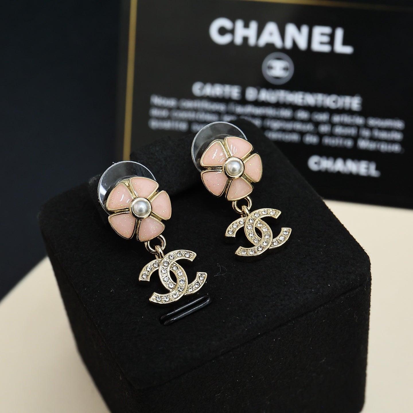 Chanel flower stud earrings with pearl center and dangling CC logo charms in silver tone