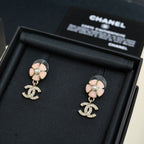 Chanel drop earrings with pink flower studs, pearl centers, and dangling CC logo charms