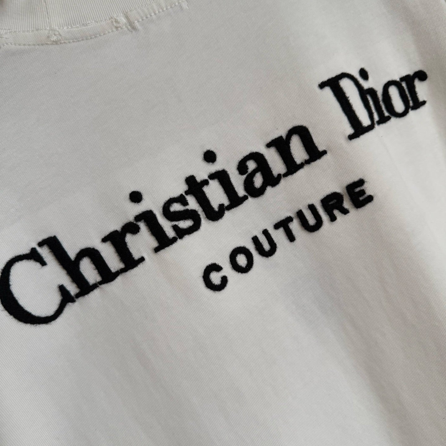 White Christian Dior T-shirt close-up of “Christian Dior” script logo