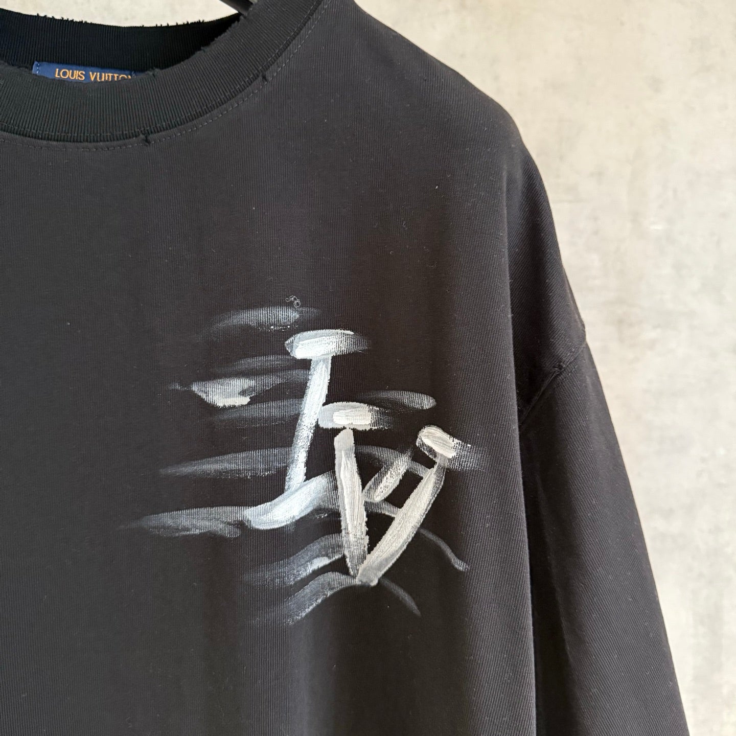 Louis Vuitton black T-shirt close-up of sleeve and centered white logo print