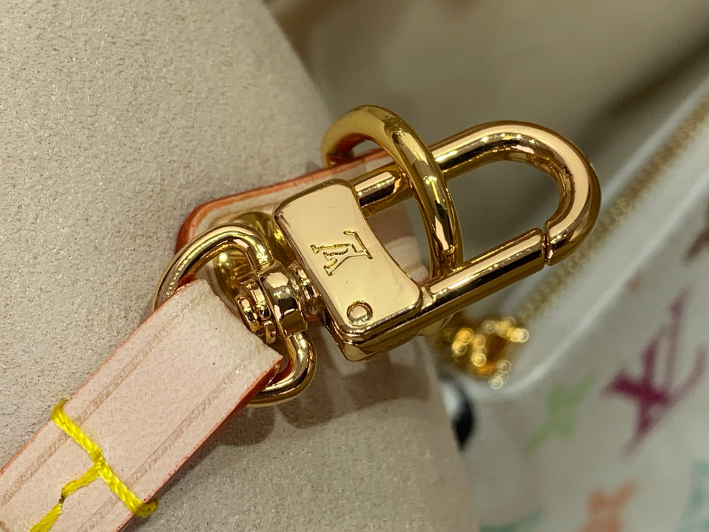 Gold-toned metal clasp attached to pale pink leather strap on a monogram bag