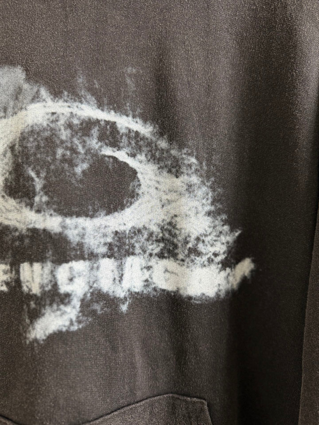 White graphic text on dark gray hoodie, close-up view