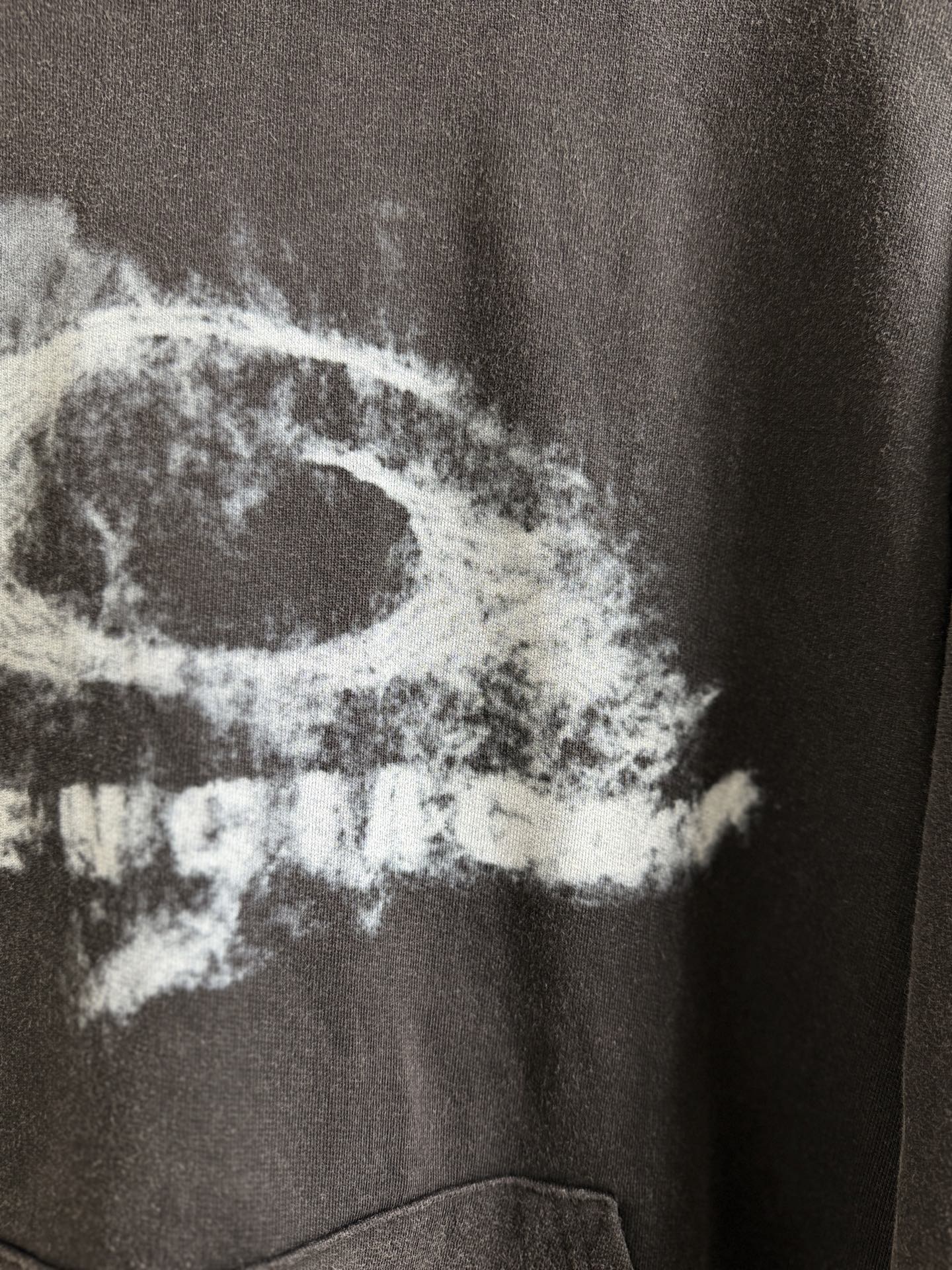 White graphic text on dark gray hoodie, close-up view