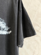 Balenciaga T-shirt sleeve and side seam in dark gray fabric, short cuff hem visible.
