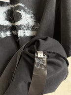 Balenciaga T-shirt close-up of neckline and fabric with care label on dark gray cloth.