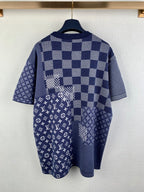 Back view of navy blue short-sleeve shirt with check pattern and monogram graphic panel.