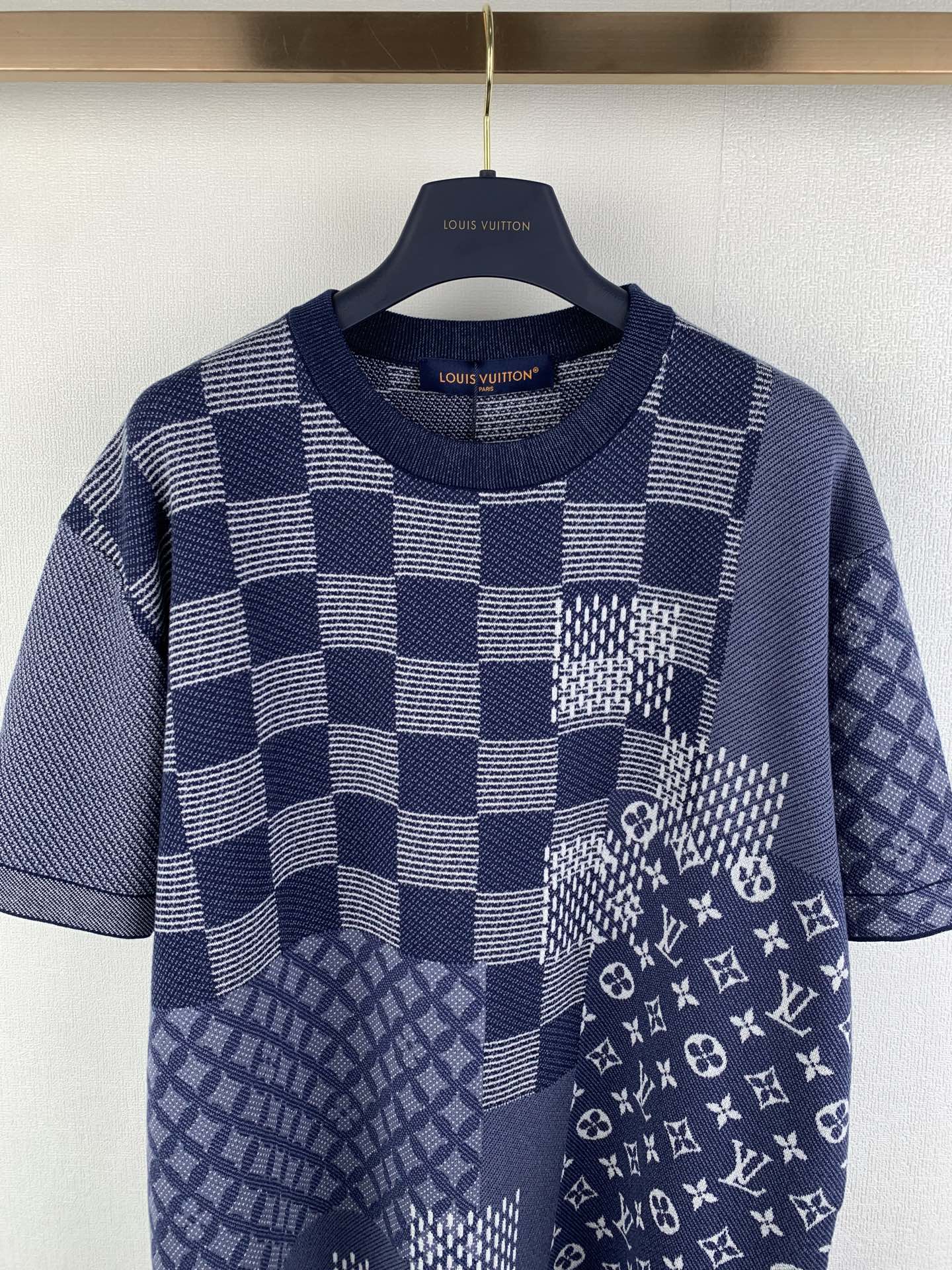 Navy blue short-sleeve shirt with oversized checker blocks and monogram patch detail.
