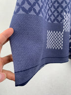 Navy blue short-sleeve shirt side view with textured knit and check patch area.